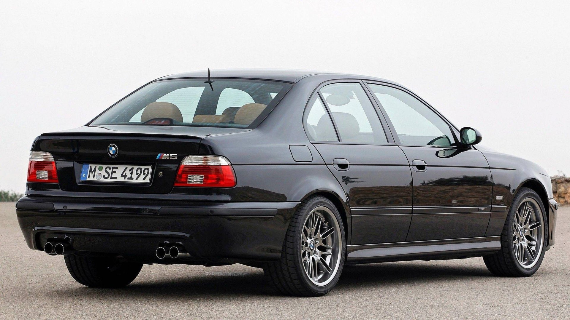 BMW M5 black sedan, rear three-quarter